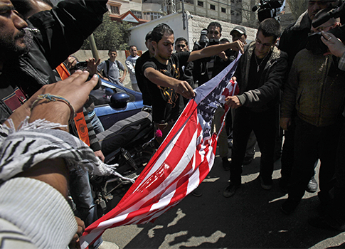 Palestinians rip an American flag during a protest against the visit of President Barack Obama / AP