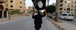 A member loyal to the Islamic State in Iraq and the Levant (ISIL) waves an ISIL flag in Raqqa June 29, 2014