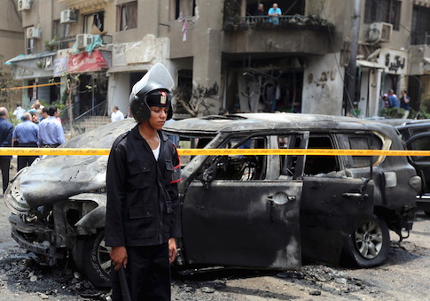 Policemen investigate the site of a car bomb attack on the convoy of Egyptian public prosecutor Hisham Barakat near his house at Heliopolis district in Cairo