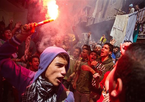 A youth carries a lit flare as supporters of the Muslim Brotherhood gather in the El-Mataria neighborhood of Cairo, Egypt on Friday, April 24, 2015