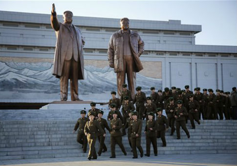North Korean soldiers walk past statues of deceased leaders Kim Il-Sung and Kim Jong-Il / AP