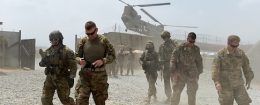 US army soldiers walk as a NATO helicopter flies overhead at coalition force Forward Operating Base (FOB) Connelly in the Khogyani district in the eastern province of Nangarhar