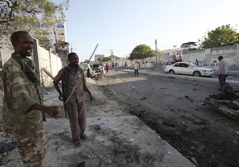 Soldiers assess the aftermath at the scene of an explosion outside Jazira hotel in Mogadishu