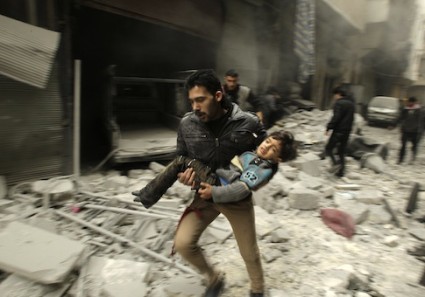 A man runs as he carries a child who survived from what activists say was an airstrike by forces loyal to Syrian President Bashar al-Assad