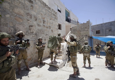 Israeli soldiers patrol during a military operation to search for three missing teenagers outside the West Bank city of Hebron