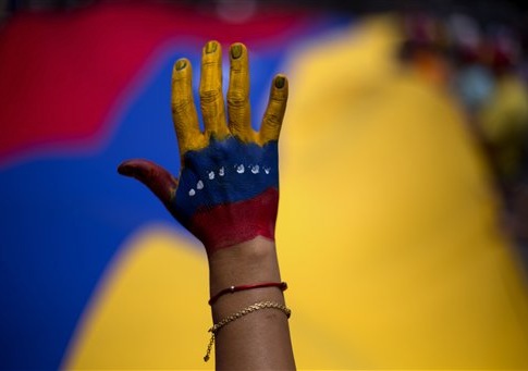 A woman with her hand painted with the colors of the Venezuelan flag attends a rally in support of opposition leader Leopoldo Lopez, in Caracas, Venezuela, Sunday, June 8