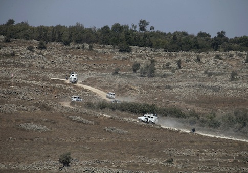 U.N. vehicles drive in Syria near the border fence with the Israeli-occupied Golan Heights