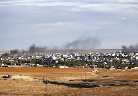 Smoke rises from the Syrian town of Kobani, seen from near the Mursitpinar crossing on the Turkish-Syrian border in the southeastern town of Suruc in Sanliurfa province, October 20,