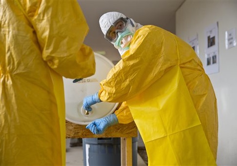 A licensed clinician sanitizes his hands after a simulated Ebola training session