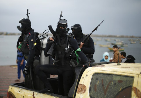 Palestinian members of the marine unit of al-Qassam Brigades, the armed wing of the Hamas movement, ride in a pickup truck as they take part in a military parade marking the 27th anniversary of Hamas' founding, in Gaza City December 14