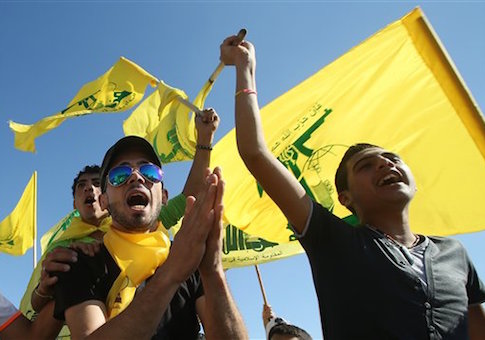 Hezbollah supporters shout slogans and wave Hezbollah flags