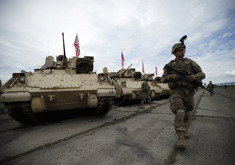 A U.S. serviceman walks past Bradley IFVs ahead an official opening ceremony of the joint U.S.-Georgian exercise Noble Partner 2015 at the Vaziani training area outside Tbilisi