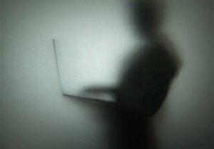 Silhouette of person using laptop