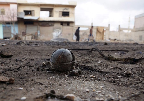 An unexploded cluster bomblet is seen along a street after airstrikes by pro-Syrian government forces in the rebel held al-Ghariyah al-Gharbiyah town, in Deraa province