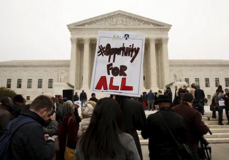 A demonstrator holds a sign aloft as the affirmative action in university admissions case was being heard at the Supreme Court in Washington