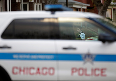 A Chicago Police officer is seen through a police vehicle window