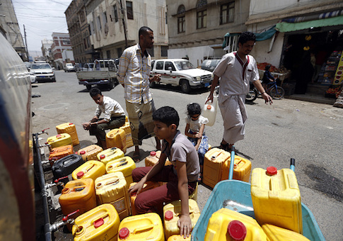 Yemenis arrive to fill jerrycans with safe drinking water from a donated water-tank in the capital Sanaa