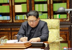 Kim Jong-Un signing an order document of a test-fire of the inter-continental ballistic rocket Hwasong-15