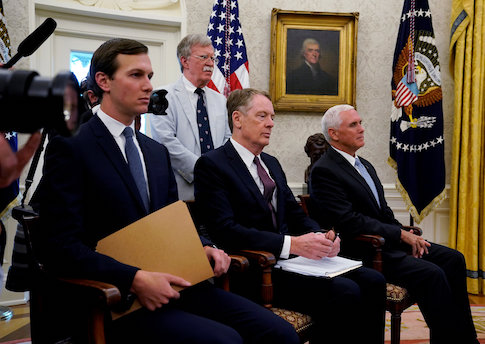 FILE PHOTO: White House aides look on as Trump announces deal on NAFTA at the White House in Washington