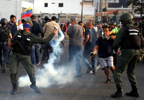A military member throws a tear gas canister near the Generalisimo Francisco de Miranda Airbase "La Carlota", in Caracas, Venezuela