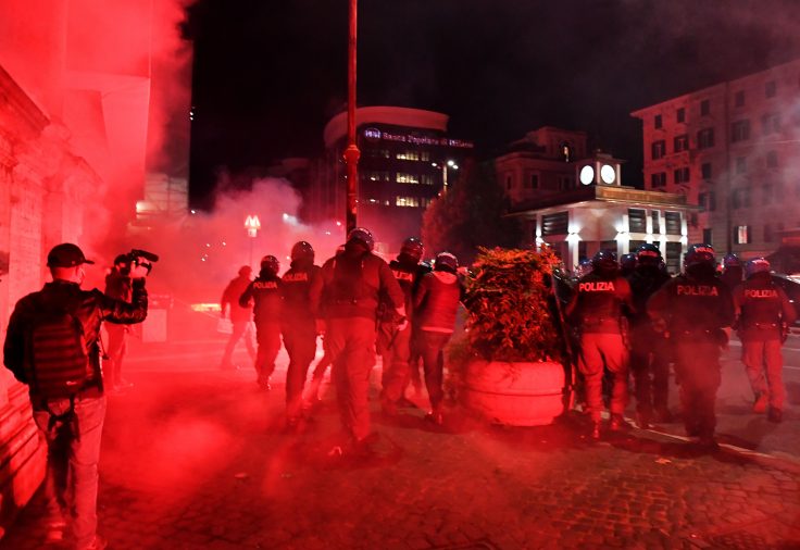 Italian police officers clash with protesters during a protest against the government restriction measures to curb the spread of COVID-19