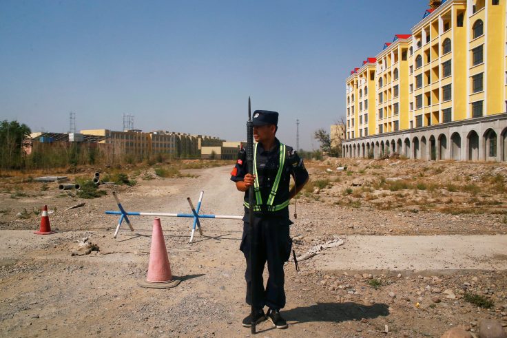 A Chinese police officer takes his position by the road near what is officially called a vocational education center in Yining in Xinjiang Uighur Autonomous Region, China