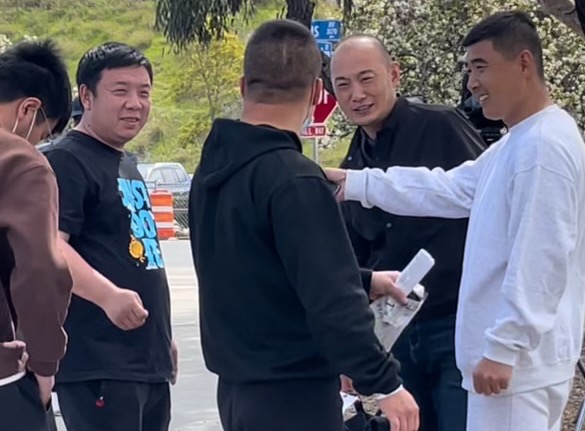 A group of Chinese nationals joke amongst themselves at a San Diego bus station after being dropped by U.S. Customs and Border Patrol 